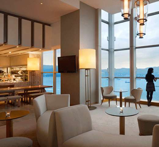 image lovely off white lounge chairs against a backdrop of bay windows overlooking the sea in a lounge
